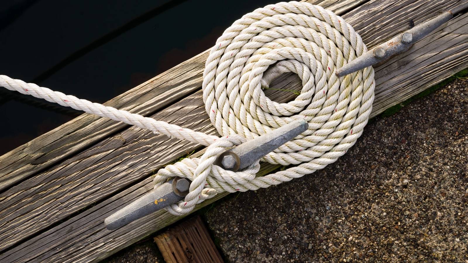 A white rope tied to two metal rings.