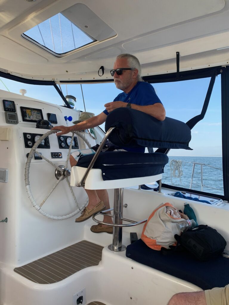 A man on the boat steering it's helm.