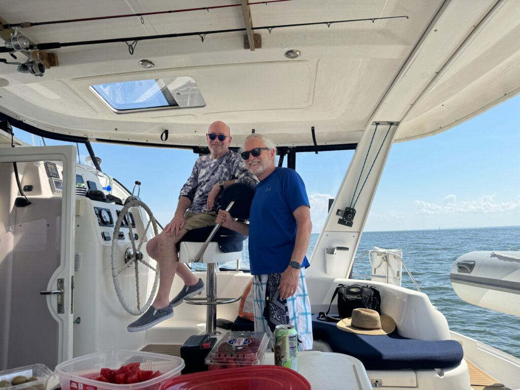 Two men on a boat in the water.