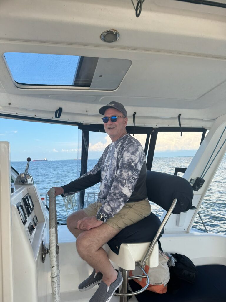 A man sitting on the seat of a boat.